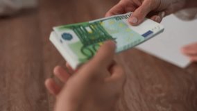 Close-up hands of unrecognizable CEO businesswoman giving bonus money to male worker in office. Man receive batch of hundred euro bills. Company leader giving money bonus to manager, slow motion. - Powered by Shutterstock - Get 15% off with code: PIKWIZARD15