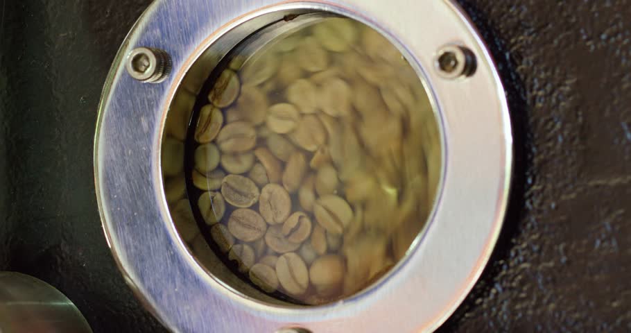 Coffee roasting machine with raw green coffee beans inside it. Royalty-Free Stock Footage #3422546707