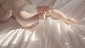 Happy laughing active healthy baby lying in bed swing hit legs. Portrait of adorable little kid having good mood. Rising son, first steps in crawling after hand plank, babycare. Closeup of feet - Powered by Shutterstock - Get 15% off with code: PIKWIZARD15