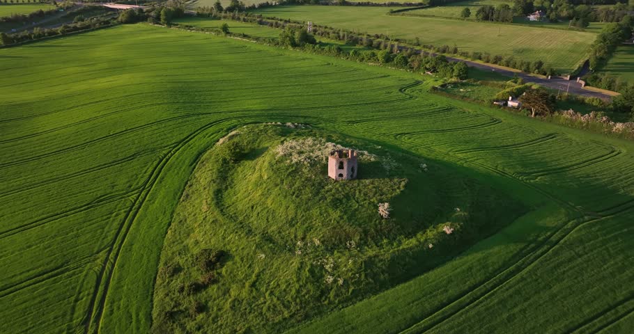 The ruins of an ancient temple stand on a green hill 4k