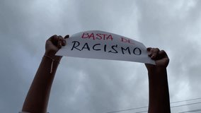video of hands holding a sign with the phrase 