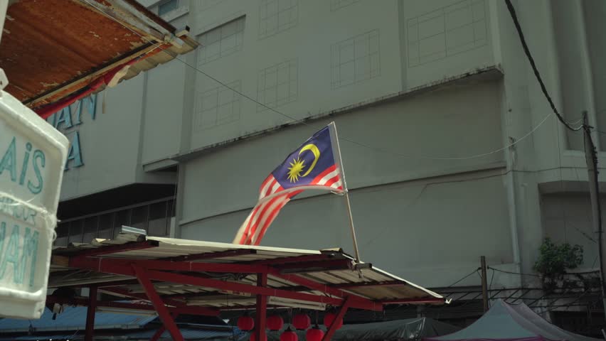 A Malaysia flag waving on a rooftop in local old town.  Royalty-Free Stock Footage #3422653437