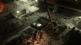 Drone video Construction of a bridge, at night, in winter, a train passes by, people and equipment are working Bird's-eye view aerial 4k