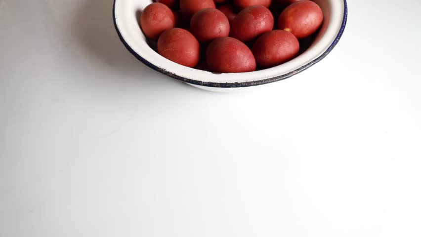 A large bowl of Easter red eggs, placed on a table, with a copyspace. Banner Royalty-Free Stock Footage #3422835161