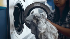 Asian woman open door of washing machine to load dirty laundry into drum in laundry shop. Comfortable life with automatic laundromat. Household chore concept. - Powered by Shutterstock - Get 15% off with code: PIKWIZARD15