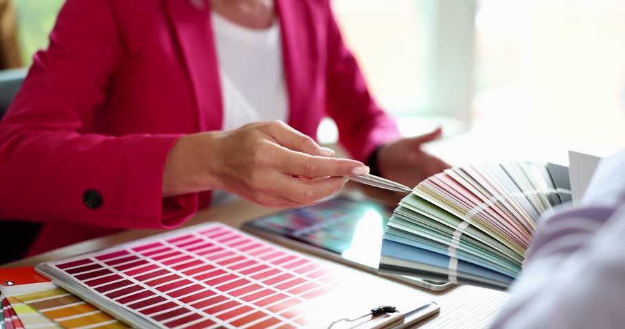 Man and woman discuss new paint colors comparing shades on set of color cards in store. Choosing color from color palette Royalty-Free Stock Footage #3422848651