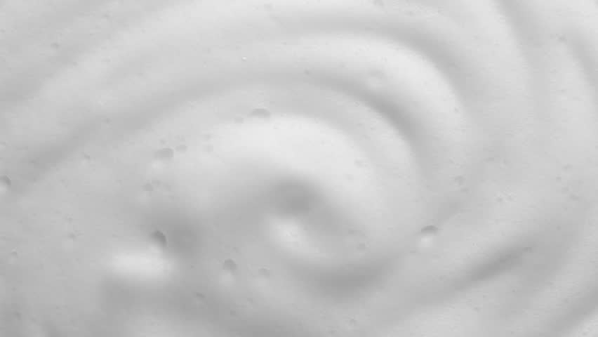 Foam texture backdrop on blue background. Liquid soap bubbles, Froth bubbles backdrop. Soap foam popping bubble rotating. Soap sud macro structure close-up. Clean, cleaning, washing, laundry 