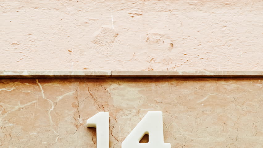 Number 14 (fourteen) affixed to the exterior of a building, with an elegant, vintage and traditional appearance Royalty-Free Stock Footage #3422957951