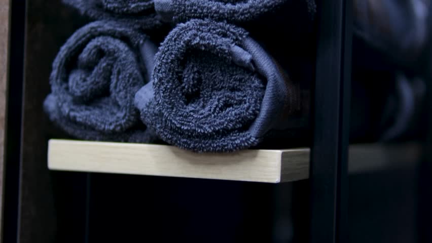 Tilting on beige polar bathing coat texture and fibers Stacks of neatly folded towels on a store shelf. Terry towels close-up in the store. Sale of interior and design items for the home Royalty-Free Stock Footage #3422964583