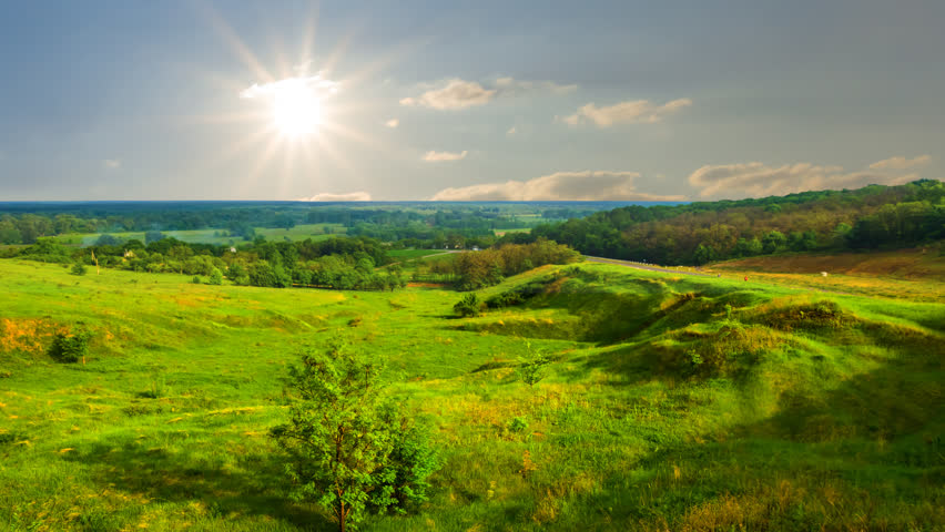 green summer prairie under a dense cloudy sky, countryside landscape time lapse scene