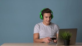 A man plays at the computer in a game with headphones