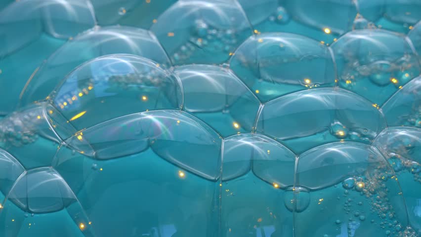 Texture of soap bubbles in close up. Bubble bath. Gel for washing or washing hands.Blue background with bursting bubbles