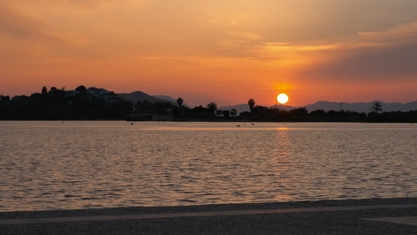 Orange sunset over the islands in the sea bay.