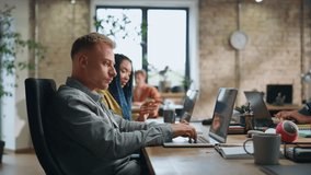Woman asking advice to colleague man sitting corporate workspace together. Young multiracial team working on laptops at coworking office. Smart coworkers consulting each other doing company tasks. - Powered by Shutterstock - Get 15% off with code: PIKWIZARD15