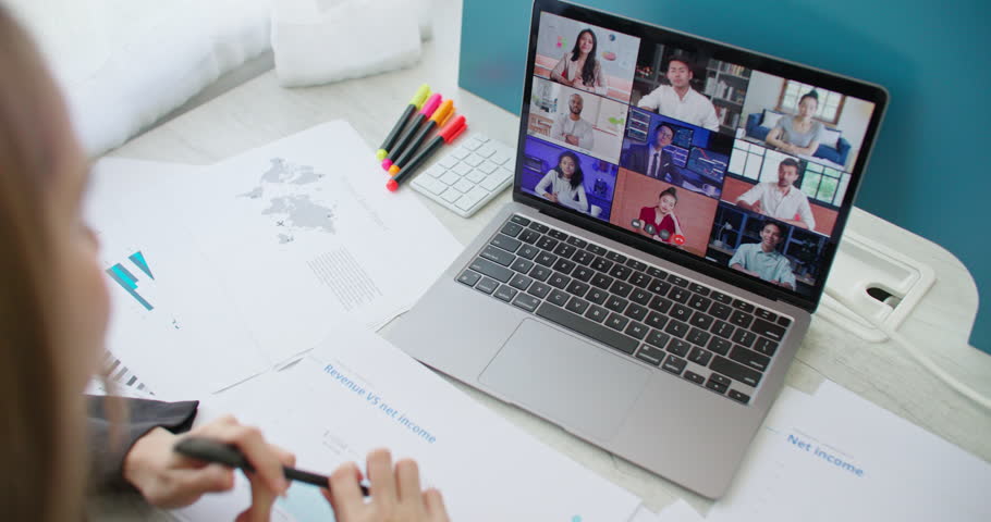 Team videocall discussing project online. Business woman using video call app remote conferencing communication meeting with boss and multiracial coworkers in group virtual chat working from home.