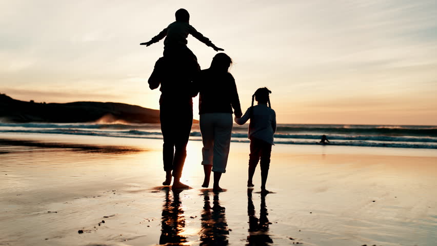 Back, piggyback and silhouette of family on beach, walking together for travel, holiday or vacation. Children, mother and father by water, ocean or sea for love, adventure or bonding at sunset Royalty-Free Stock Footage #3423473429
