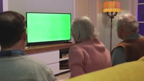 Family watching TV. Green screen. Two couples, an elderly and a middle-aged couple, are sitting on the couch at home. In front of them is a green screen TV. Horizontal panning.
 - Powered by Shutterstock - Get 15% off with code: PIKWIZARD15