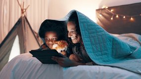 Tablet, search and mother and son on a bed with cartoon, movie or streaming funny video in their home. Digital, app and mom with kid in a bedroom for online comic, love and bonding with blanket fort