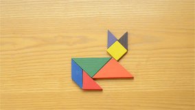 man playing wooden tangram and making different shapes of fox fourth of the five clips of this series