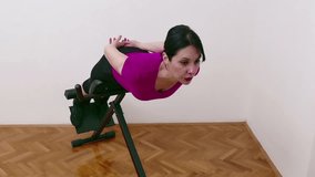 Young woman exercising on a bench for back hyperextension, Video Clip 4K