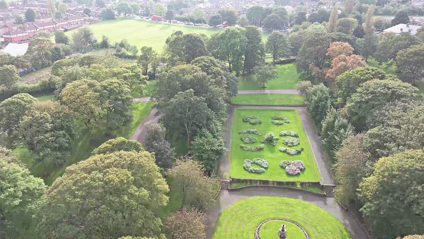 A beautiful top-view shot of a green park in Bradford Centre. Elegant lawns are decorating the ground below the trees.