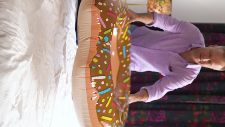 Happy family couple with two children unpacking at the hotel room and having fun. Summer family vacation at the hotel. The family unpacks a suitcase with clothes.