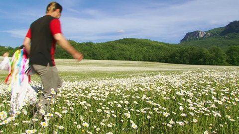 Father and daughter running across the field of daisies. Slow motion.
Father and daughter.