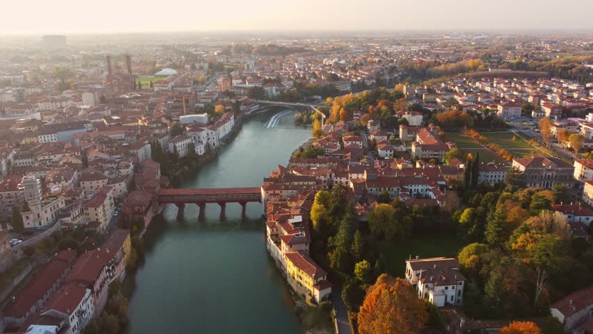 AERIAL: Bassano del Grappa historical bridge panoramic view in a sunny day with flare. Royalty-Free Stock Footage #3423825183
