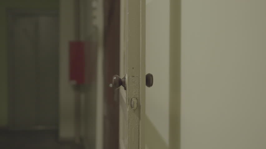 Ajar vintage door in a dimly lit hallway creating a mysterious and suspenseful atmosphere Royalty-Free Stock Footage #3423834209