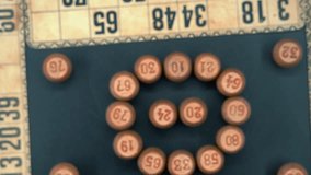 Creative close-up smooth zoom in shot from above of a Bingo wooden barrels in a circle, woody figures, old numbers background, vintage board game, professional lighting, slow motion 4K video