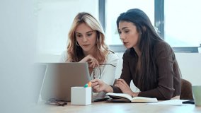 Video of two elegant attractive businesswomen talking while working together with laptop in a modern startup - Powered by Shutterstock - Get 15% off with code: PIKWIZARD15