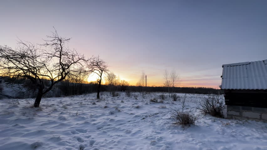 Bathhouse in village in winter time. Smoke from a bathhouse chimney in village. Russian Bath House in countryside. Wooden home in rural in winter. Smoke from Country houses chimney in countryside.