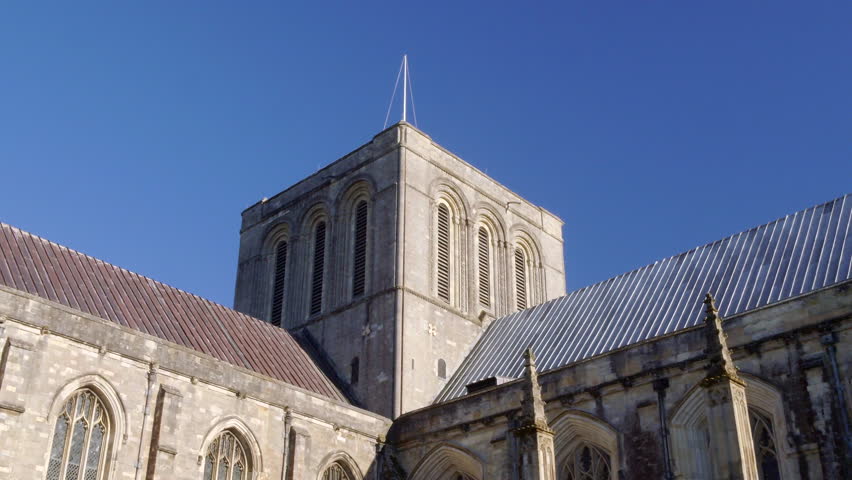 Drone sweeping shot of the Winchester Cathedral central tower during Summer, in Hampshire, UK, 4K