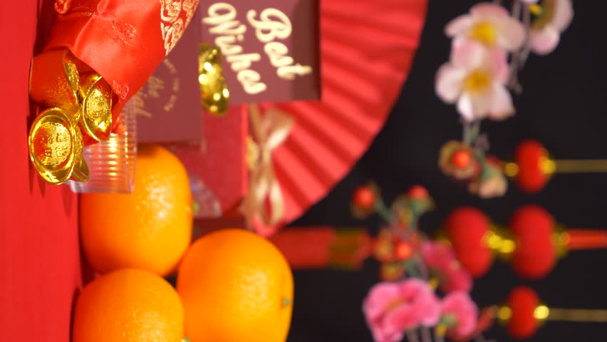 looping of red Chinese Lunar New Year background. gold in silk bag, red gift box with text best wishes, oranges, paper fan, plum blossom branch, candle sway and Chinese new year ornament for celebrate