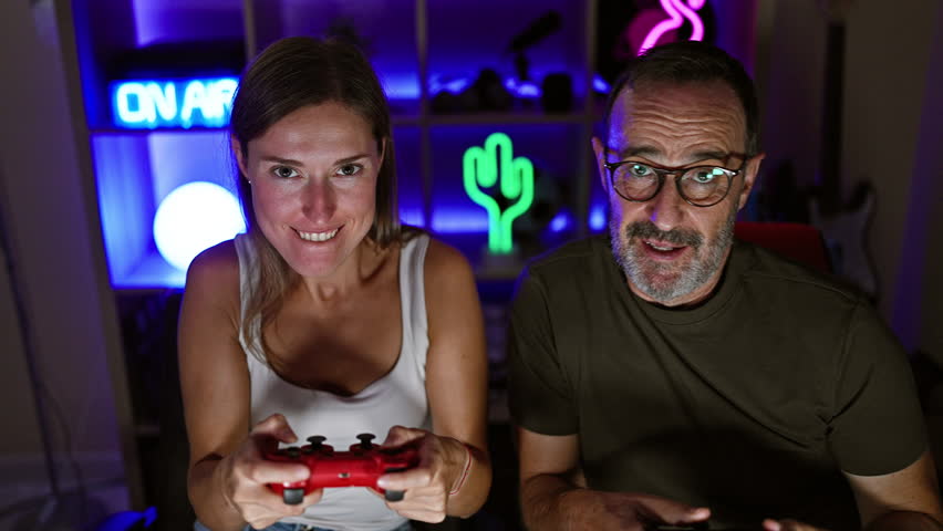 Two gamers playing video game using joystick at gaming room