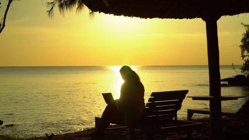 The girl works on the computer on the beach. A decline on the island of Phu Quoc.