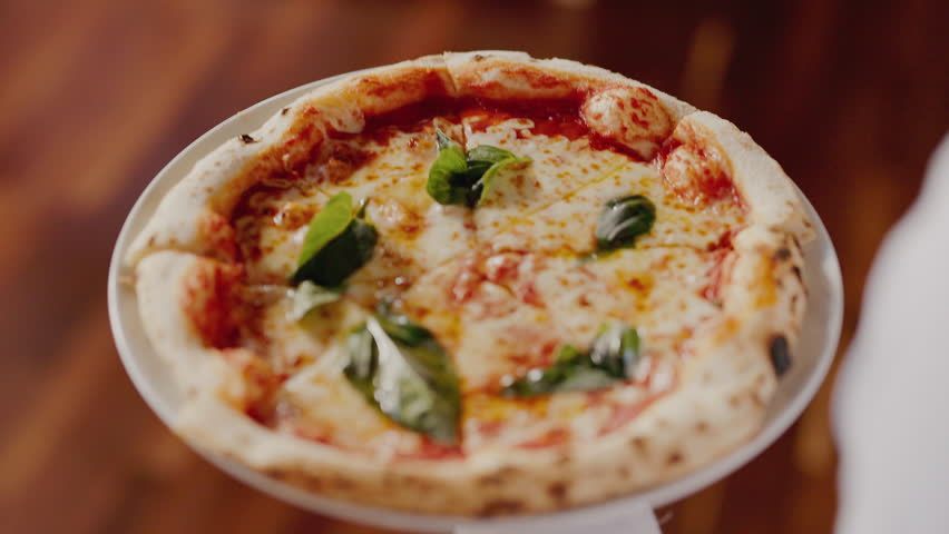 Waiter Carries An Appetizing Pizza With Cheese And Tomato Sauce.