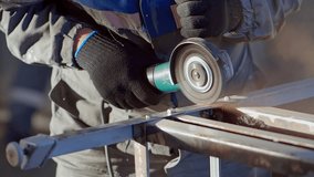Mechanic works with angle grinder and cleans metal from old paint. Slow-motion close-up video. Worker's hands with tool. Preparing metal for painting. Anti-corrosion treatment.