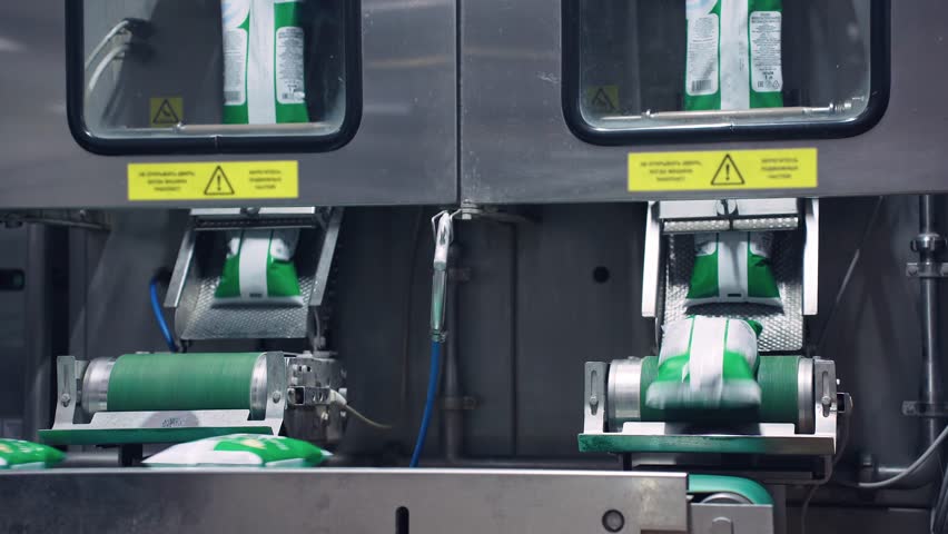 Modern dairy food production factory, automated production line. Automatic milk bottling conveyor. Pouring milk into plastic bags. Food industry, milk packages move along a conveyor belt.