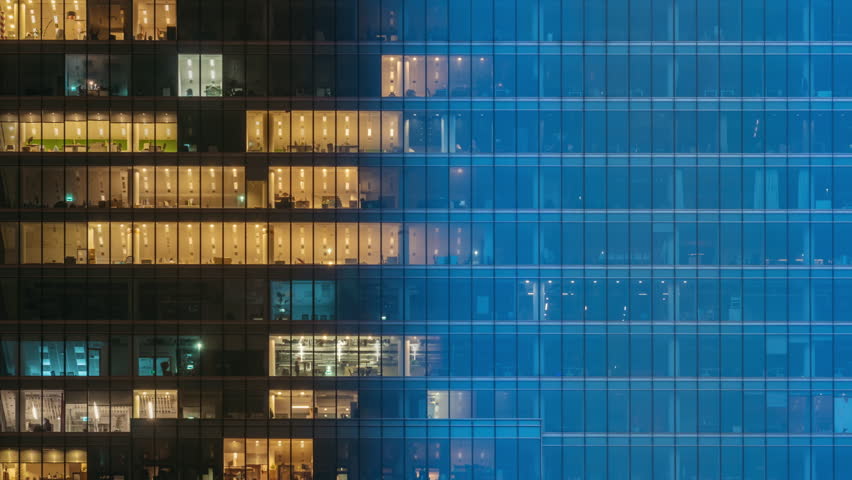 Day to night time-lapse timeslice effect blinking office windows lights, high-rise glass skyscraper business building in city downtown, work non-stop, turn on and off, endless work without breaks