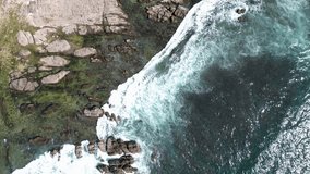 Video of a sea view with coastal rock edges taken from a sideways vertical position
