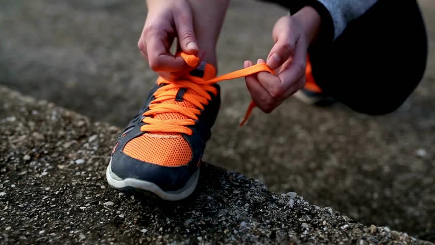 Athlete tied up shoelaces of his running shoes before exercising outdoor. Young man tying shoelace on sport shoes outdoors, closeup shot. Closeup view of man tying shoelaces on his sneakers. Royalty-Free Stock Footage #3424621367
