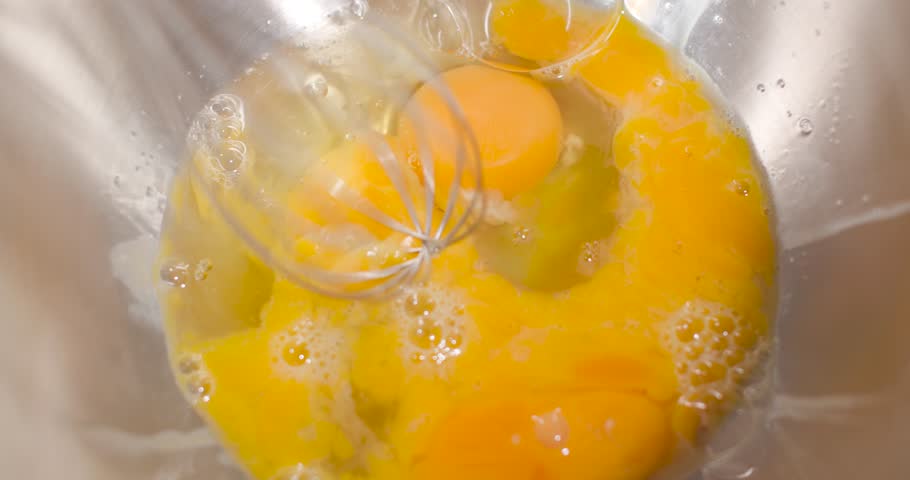 Dipping a switched on mixer into a metal bowl, for whipping eggs. Royalty-Free Stock Footage #3424736353