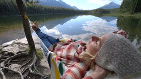 Shot of a young woman relaxing on hammock bu the mountain lake in Jasper national park, Alberta, Canada
People travel relaxation concept