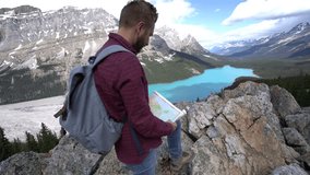 Young man hiking in Banff national park consulting trail map for directions. On top of Peyto lake, Alberta, Canada
People travel outdoor pursuit concept