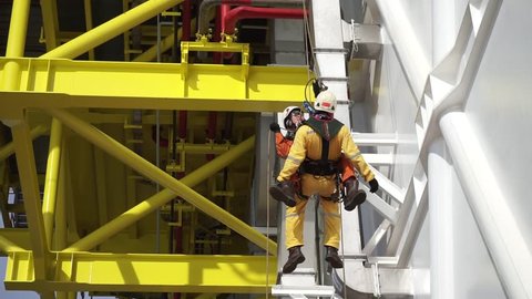 KELANTAN, MALAYSIA-MAY 20 2017 : Unidentified local Abseiler demonstrate how to rescue his colleague who fainted suddenly during working at heights on oil and gas platform.