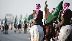 Riyadh, Saudi Arabia – September 21st 2023: Celebrating national and founding day in Riyadh the capital of Saudi Arabia. Group of knights with traditional dress holding the Saudi national green flag - Powered by Shutterstock - Get 15% off with code: PIKWIZARD15