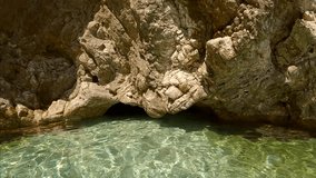 POV underwater shot, Close up of hands of man dives and swimming inside an underwater cave, is woman sitting inside the cave, Slow motion, Mediterranean sea, First person view