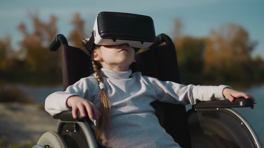 Female kid with disability plays computer game using VR headset. Preschooler girl moves head looking at new location on blurred background closeup Royalty-Free Stock Footage #3425106413