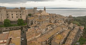 Aerial view of the castle in Bracciano Italy. High walls of an ancient fortress on a mountain on the shore of a lake in a beautiful landscape, a city. High quality 4k footage